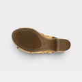 Bottom sole view of a tan leather wedge sandal showing textured rubber outsole and heel