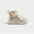 Women's metallic gold quilted puffer ankle boot with chunky white ribbed sole