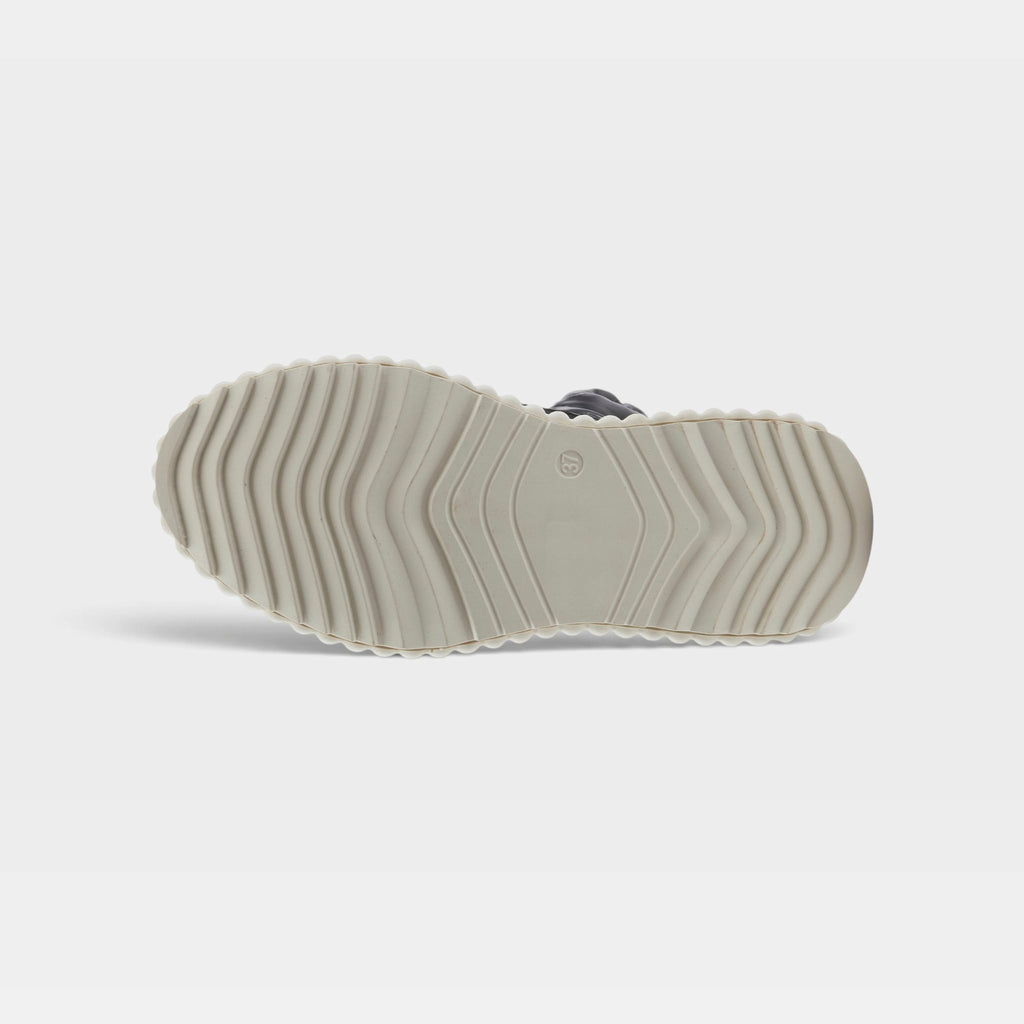 Bottom sole view of a chunky platform shoe with zigzag tread pattern