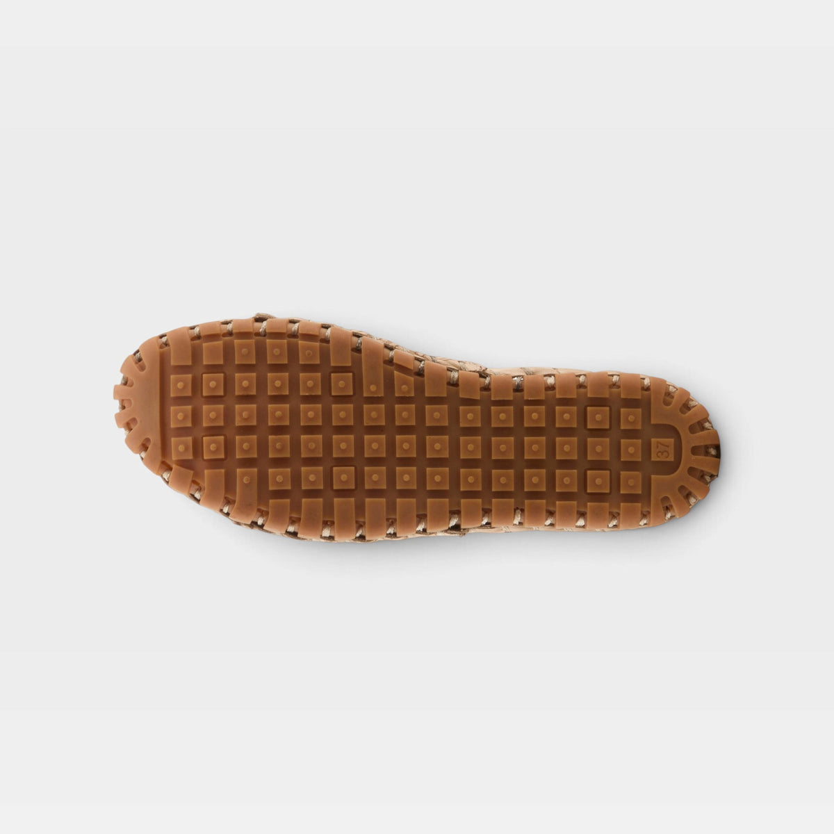 Bottom sole view of a women's slip-on shoe with waffle-patterned rubber outsole and stitched upper