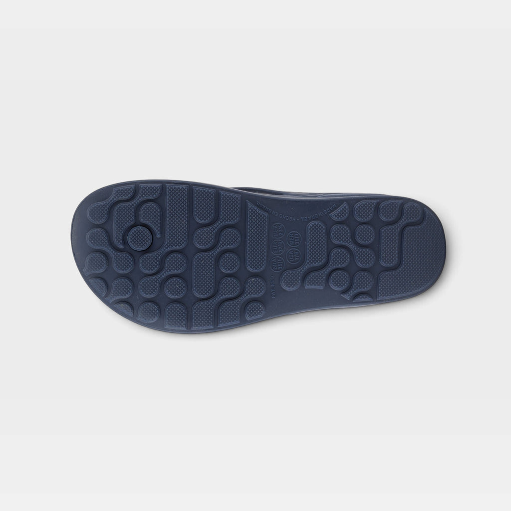 Bottom sole view of a flip flop sandal showing textured traction pattern and contoured footbed