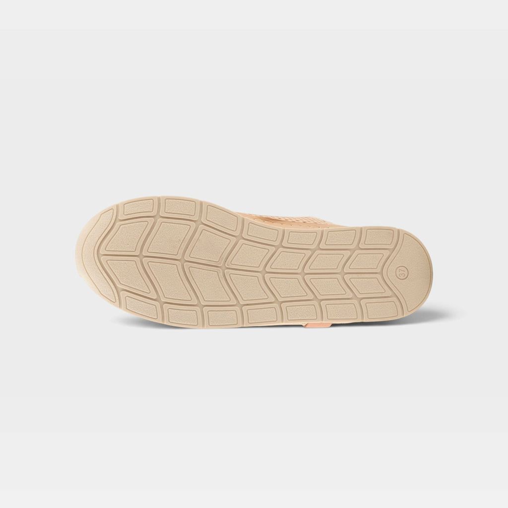 Bottom sole view of a beige women's casual shoe with diamond-pattern tread