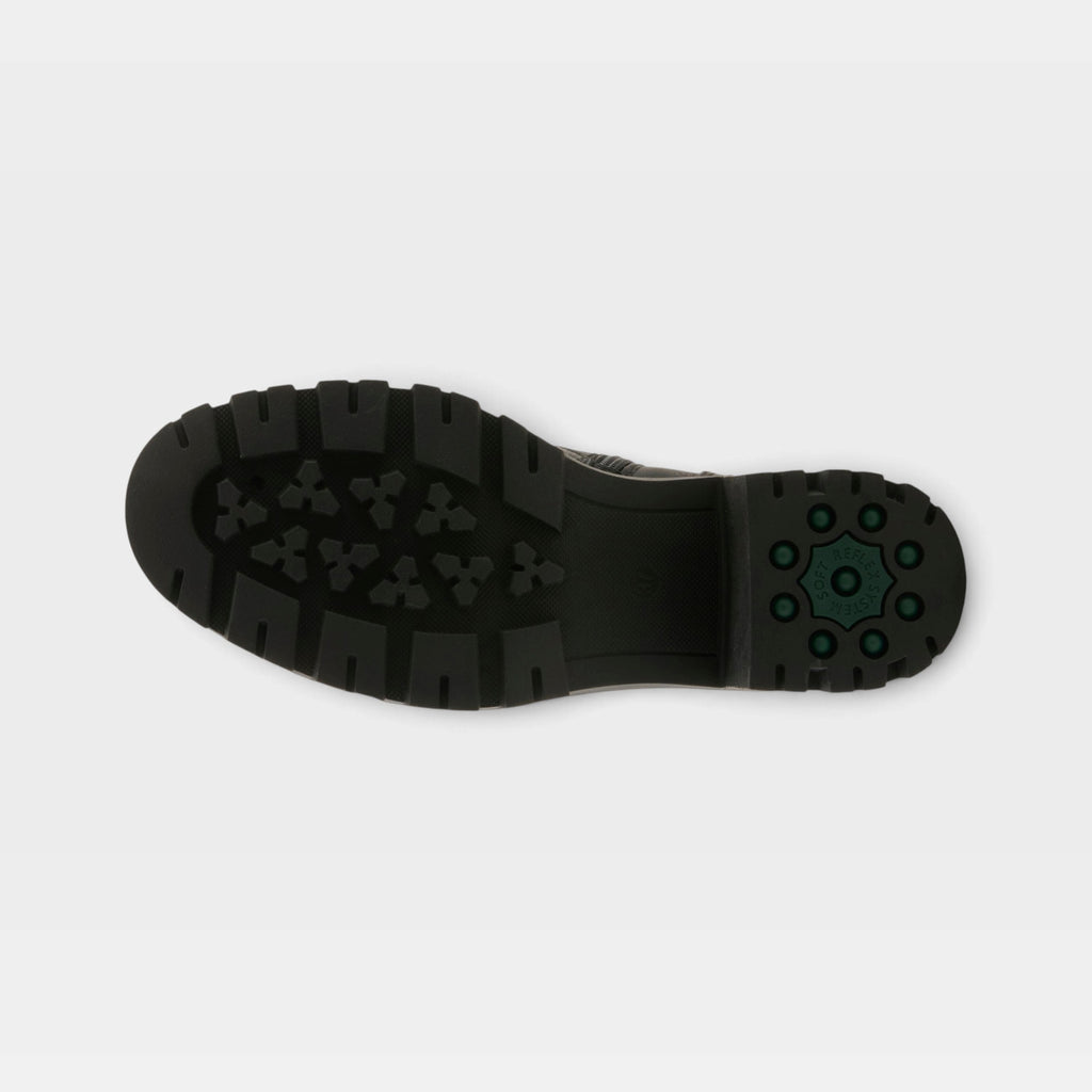 Bottom sole view of a chunky black lug-sole boot with green rubber heel accents