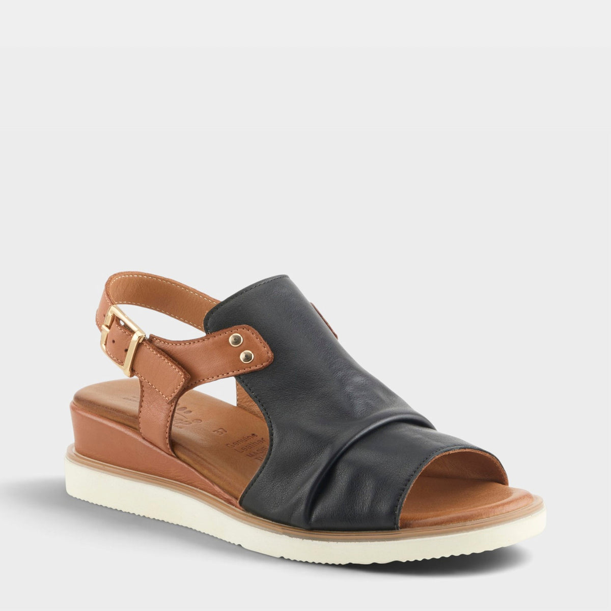 Women's leather wedge sandal with black upper, tan slingback strap, and gold buckle