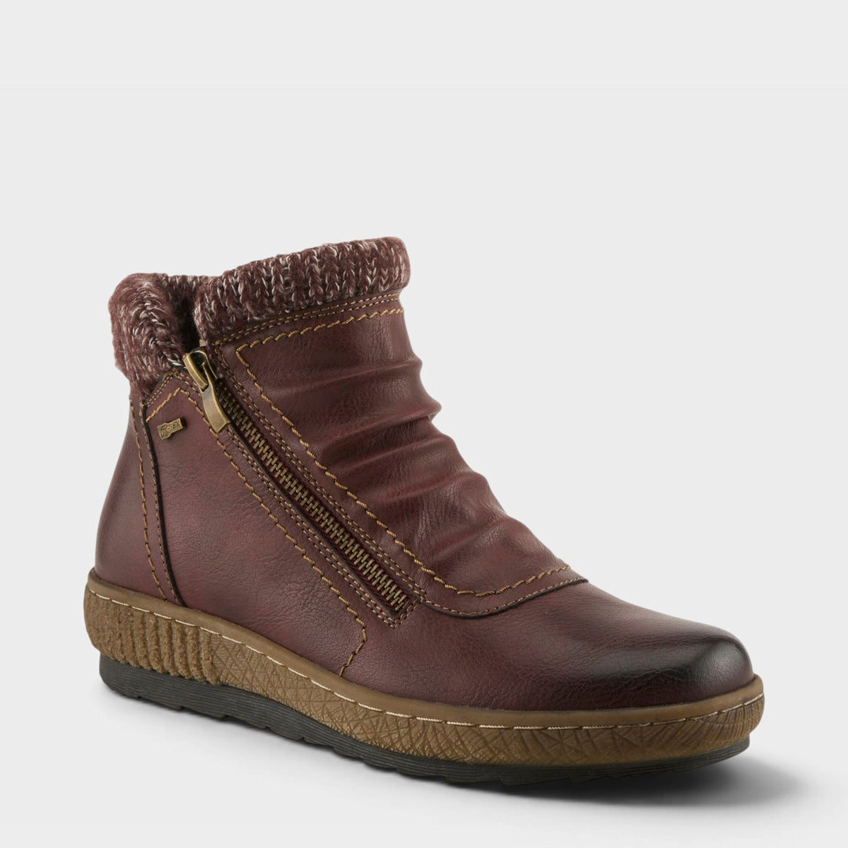 Women's ankle boot with knit cuff collar, side zipper, and ruched leather upper on cushioned sole