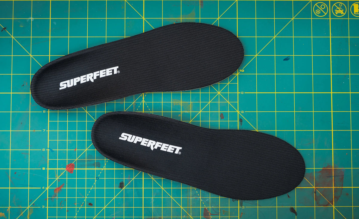 Pair of Superfeet AP Support Low insoles laid flat on a green cutting mat